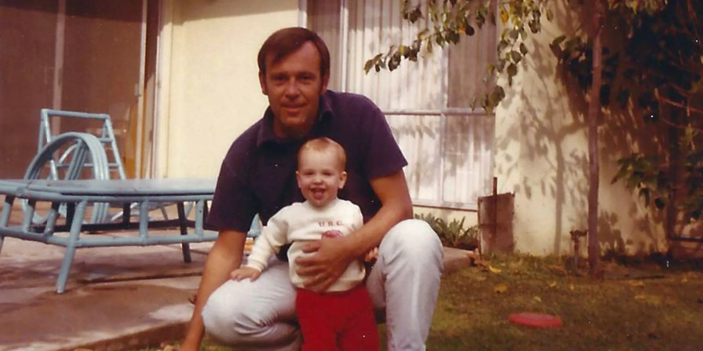 Jack Coulter kneeling in the yard with his young son Chris, who later founded Saga