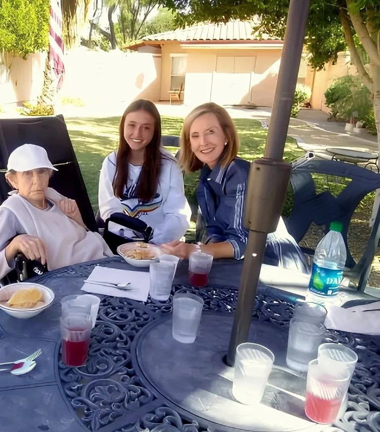 A resident and family sharing lunch on the patio at Barton House