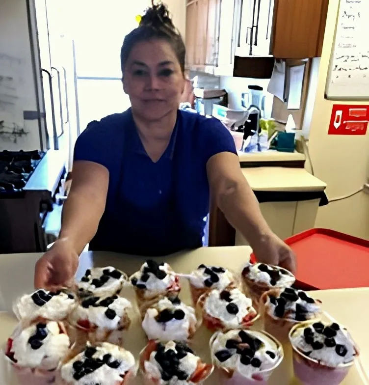 A team member with a tray of berry desserts at Barton House