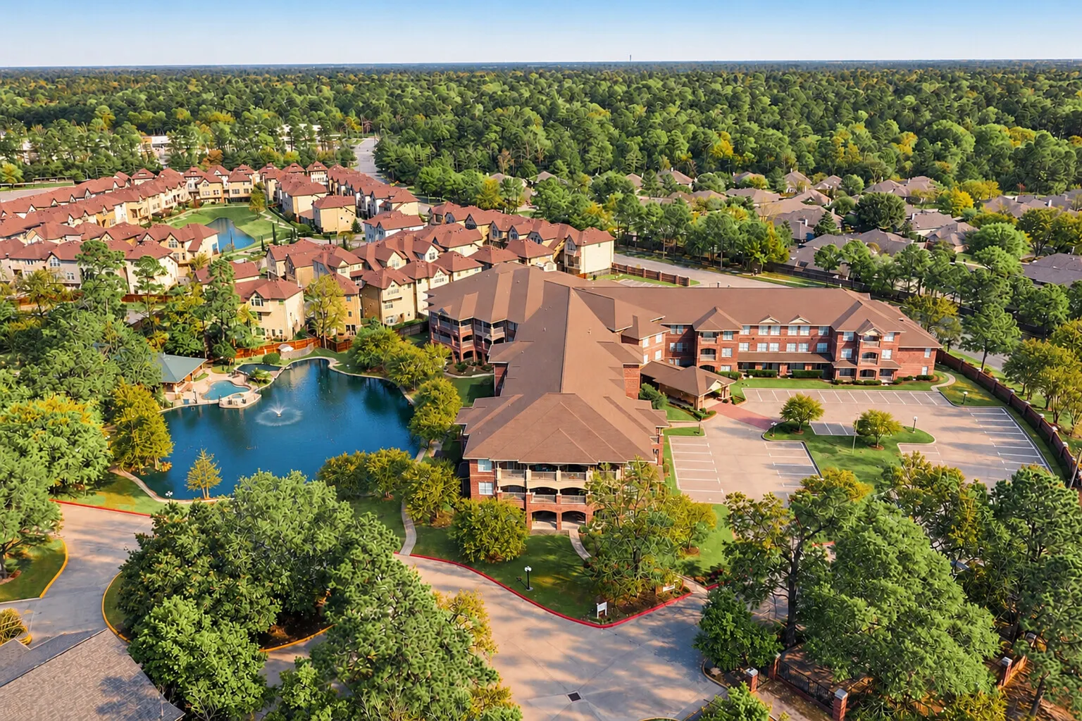Aerial view of The Terraces at Kingwood, the pond with its fountain and the wooded neighborhoods of Kingwood