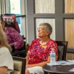 Show photo 93: A resident listening during a talk in the bistro