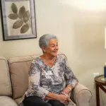 Show photo 71: A resident in her living room