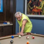 Show photo 83: A resident playing billiards