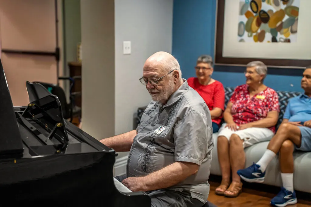 A resident playing the piano for neighbors