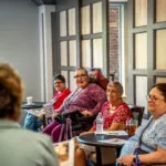 Show photo 78: Residents gathered for a talk in the bistro