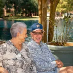 Show photo 11: Two residents sharing a laugh by the pond