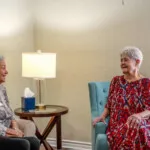 Show photo 61: Two residents visiting in a residence