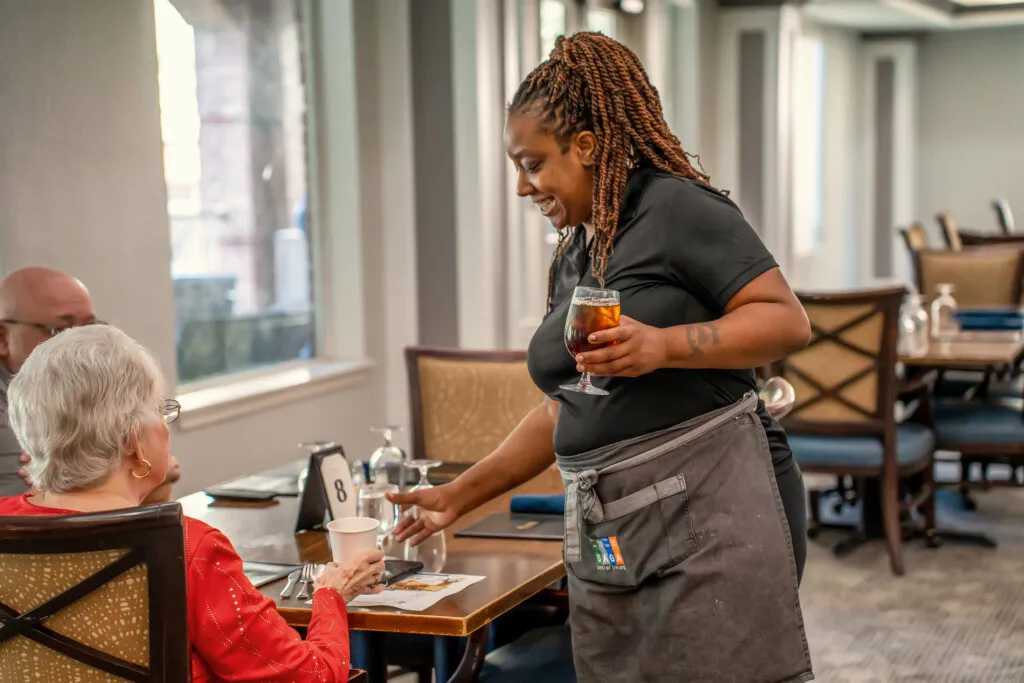 A server pouring iced tea at lunch