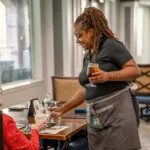 Show photo 35: A server pouring iced tea at lunch